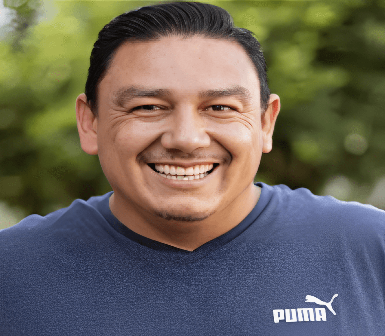 A man dressed in a Puma t-shirt, featuring the iconic logo, stands confidently.